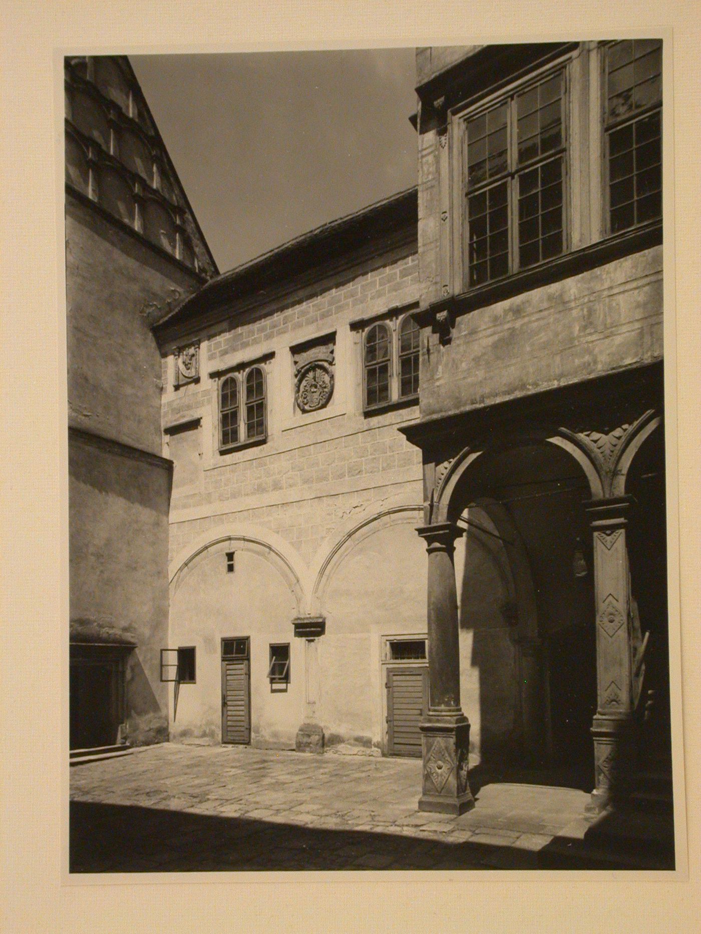 View of a courtyard showing a building façade with windows and panels with relief carvings, possibly in the Telc Château, Telc, Czechoslovakia (now Czech Republic)