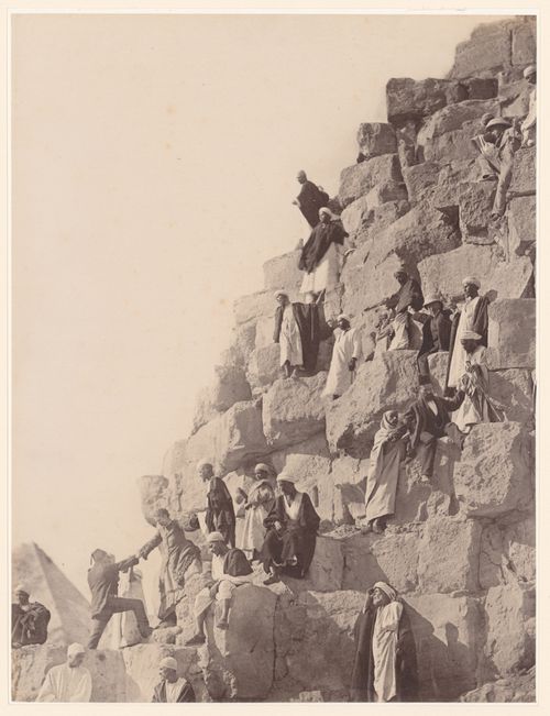 Partial view of a pyramid showing men climbing on the stone blocks, Egypt