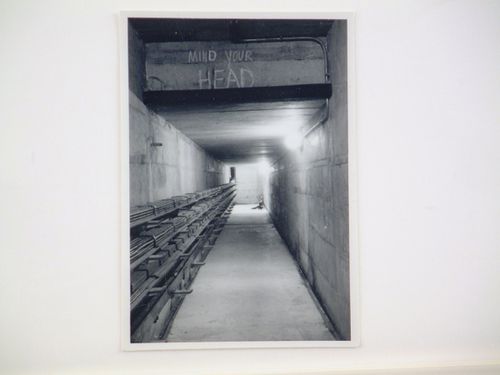 View of interior of concrete tunnel, labelled "Mind Your Head"