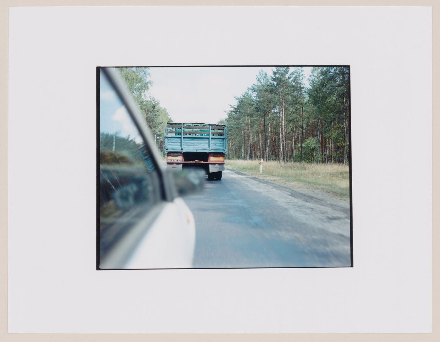 View of a truck on a road and trees at the roadside showing an automobile in the foreground, Dlugie, near Strzelce Kraje'nskie, Poland (from the series "In between cities")