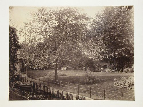 Garden scene with canal, boat and bridge in the far right, England