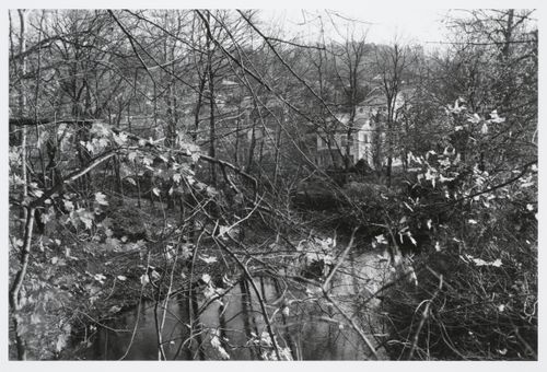 Community of houses on hill seen through woods, and across a small creek, Tarrytown, New York