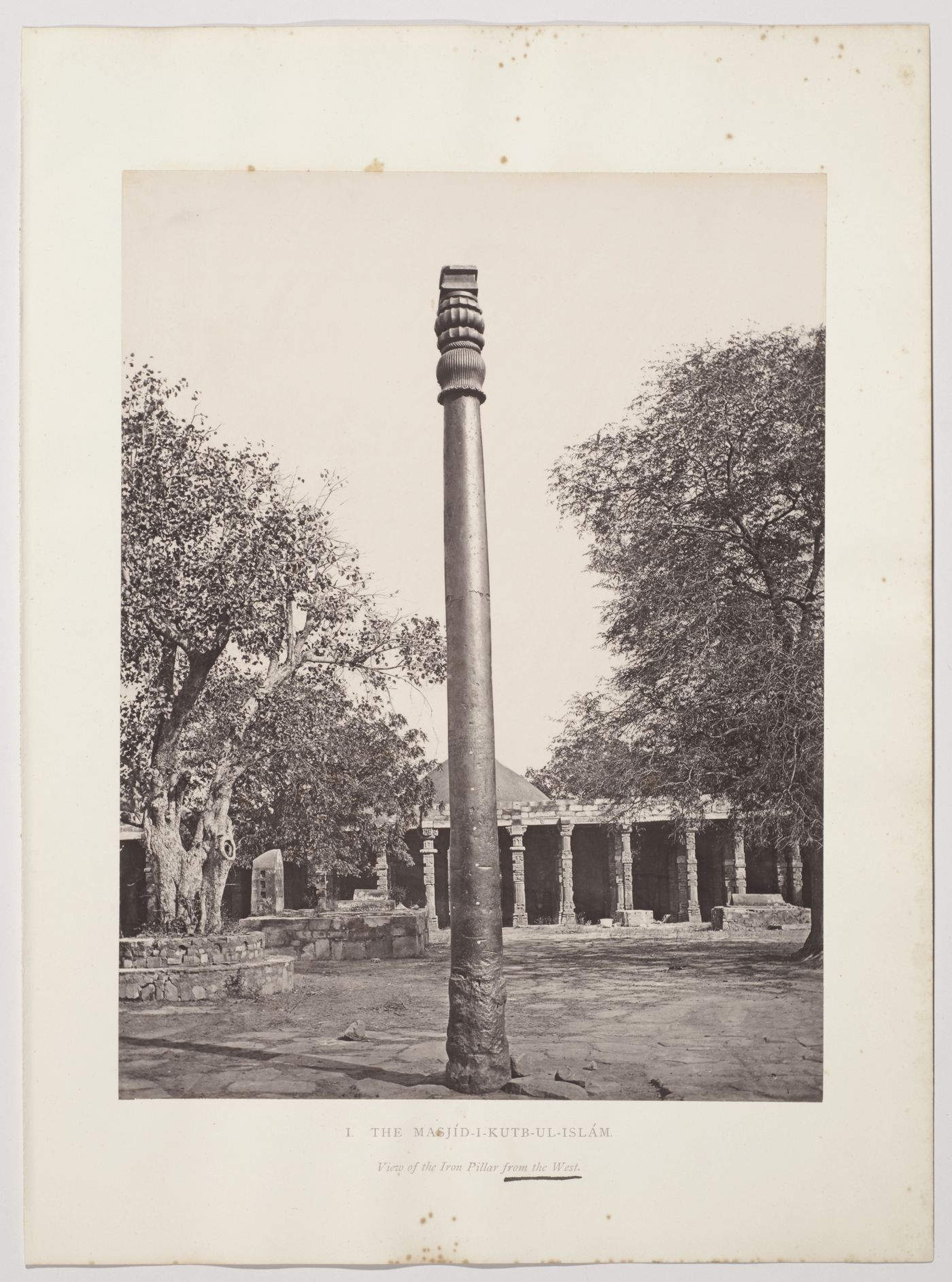 View of the Iron Pillar with the courtyard and colonnade of the Quwwat al-Islam [Might of Islam] Mosque in the background, Quwwat al-Islam Mosque Complex, Delhi, India