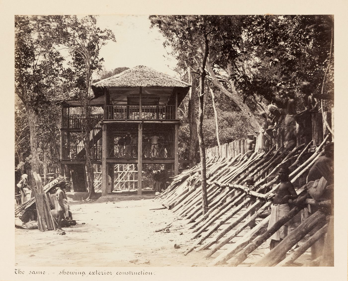 View of the grandstand and kraal with people and a fence on the right, Kornegalle, Ceylon (now Sri Lanka)