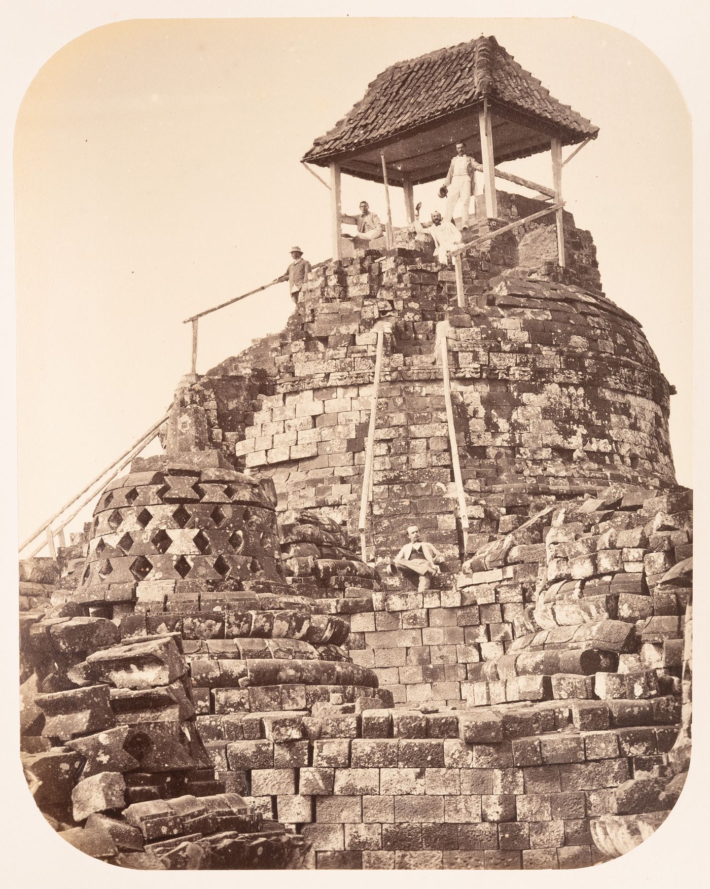 Group portrait of men on the central stupa, Borobudur, Dutch East Indies (now Indonesia)