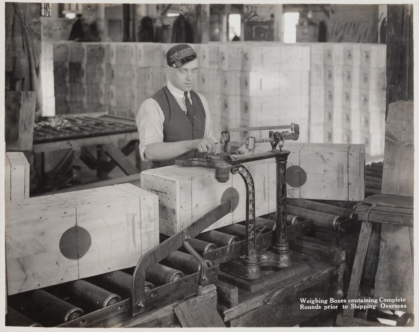 Interior view of workers weighing boxes containing complete rounds prior to shipping at the Energite Explosives Plant No. 3, the Shell Loading Plant, Renfrew, Ontario, Canada