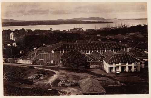 View of the Jail with the Roman Catholic Convent and Church of St. Patrick on the left and houses, a harbour and seaway in the background, Moulmein, Burma (now Myanmar)