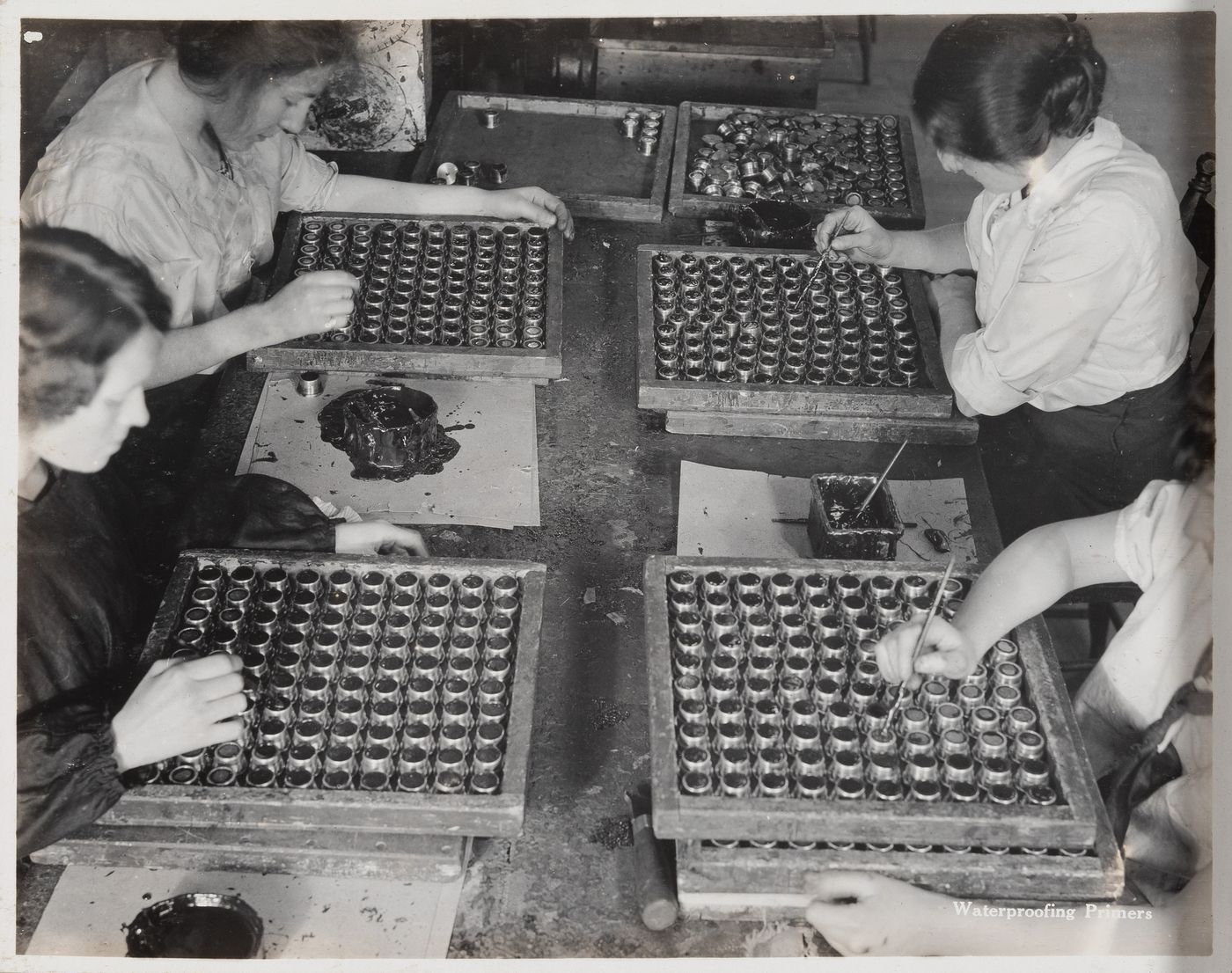 Interior view of workers waterproofing primers at the Energite Explosives Plant No. 3, the Shell Loading Plant, Renfrew, Ontario, Canada