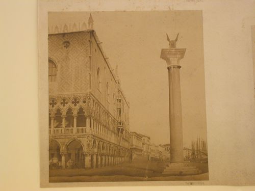 Side view of the canal façade of the Palazzo ducale showing a column with a statue of the winged lion of Venice, Venice, Italy