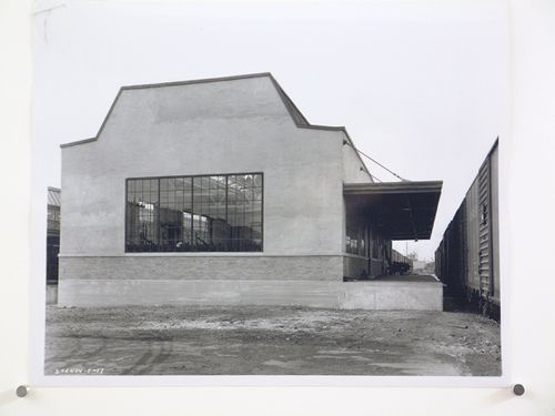 View of the principal and lateral façades of the Paint Mixing and Storage Building with the loading dock and a train on the right, General Motors Corporation Chevrolet division Commercial Body Plant, Indianapolis, Indiana