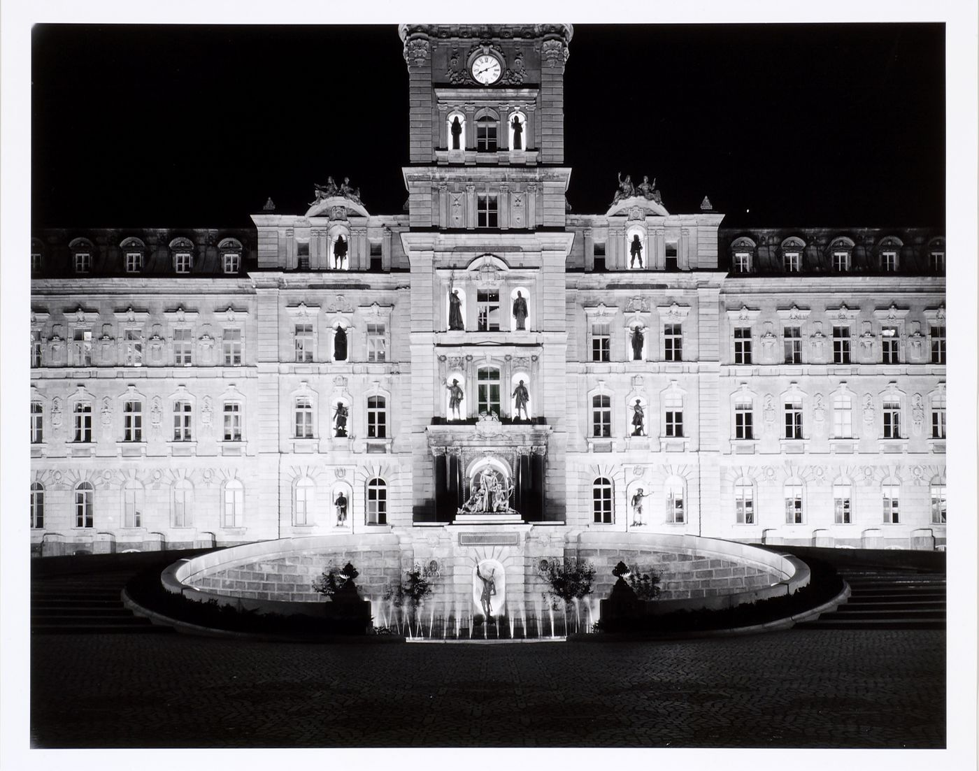 Night view of the principal façade of the Hôtel du Parlement showing the fountain in the foreground, avenue Honoré-Mercier, Québec City, Québec