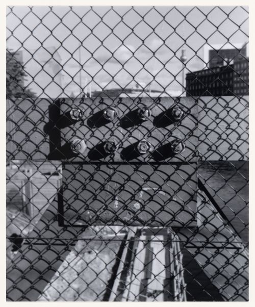 View of a chain-link fence, metal beams and bolts showing the Berliner Fernsehturm and other buildings in the background, Berlin, Germany, from the artist book "The Potsdamer Project"