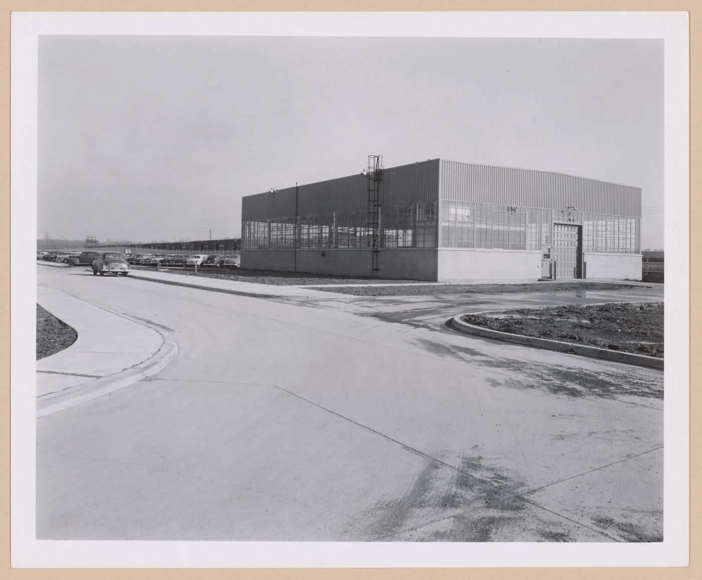 View of the principal and lateral façades of the Garage [?] with a parking lot on the left, Ford Motor Company Automobile Assembly Plant, Hamburg, New York