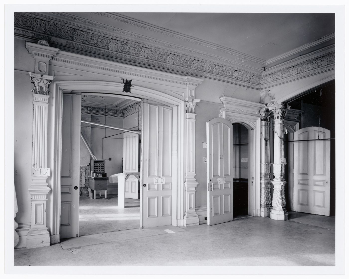 Interior view of a reception room showing the Sottsass Room through open pocket doors, Shaughnessy House under renovation, Montréal, Québec
