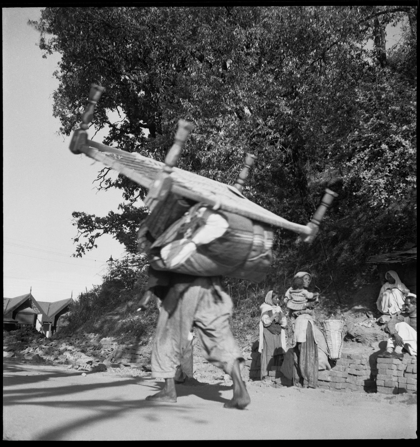 Man transporting a bed and luggage on his back in Chandigarh, India