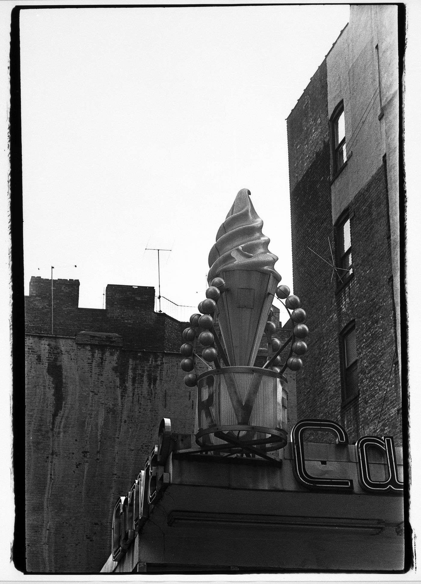 Partial view of a roof top showing signs with an artificial ice cream cone, New York City, New York