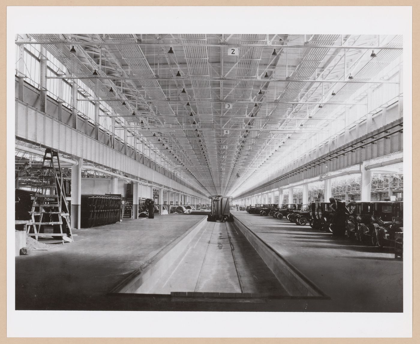 Interior view of the Assembly [?] Building showing cars and a train at the loading dock, Ford Motor Company Automobile Assembly Plant, Richmond, California