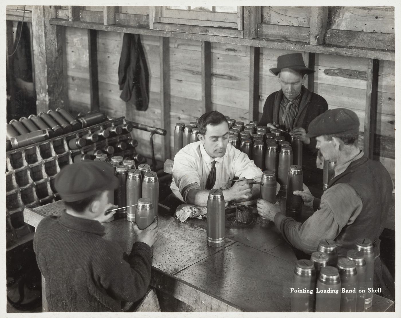 Interior view of workers painting loading band on shell at the Energite Explosives Plant No. 3, the Shell Loading Plant, Renfrew, Ontario, Canada