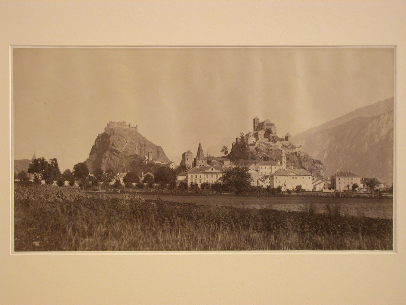 Unidentified town; general view from a distance, including many houses, and a castle on a cliff, France ?