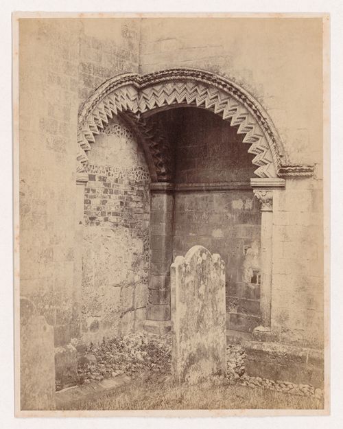 View of two intersecting arches on the exterior of a church with a tombstone in the foreground, England