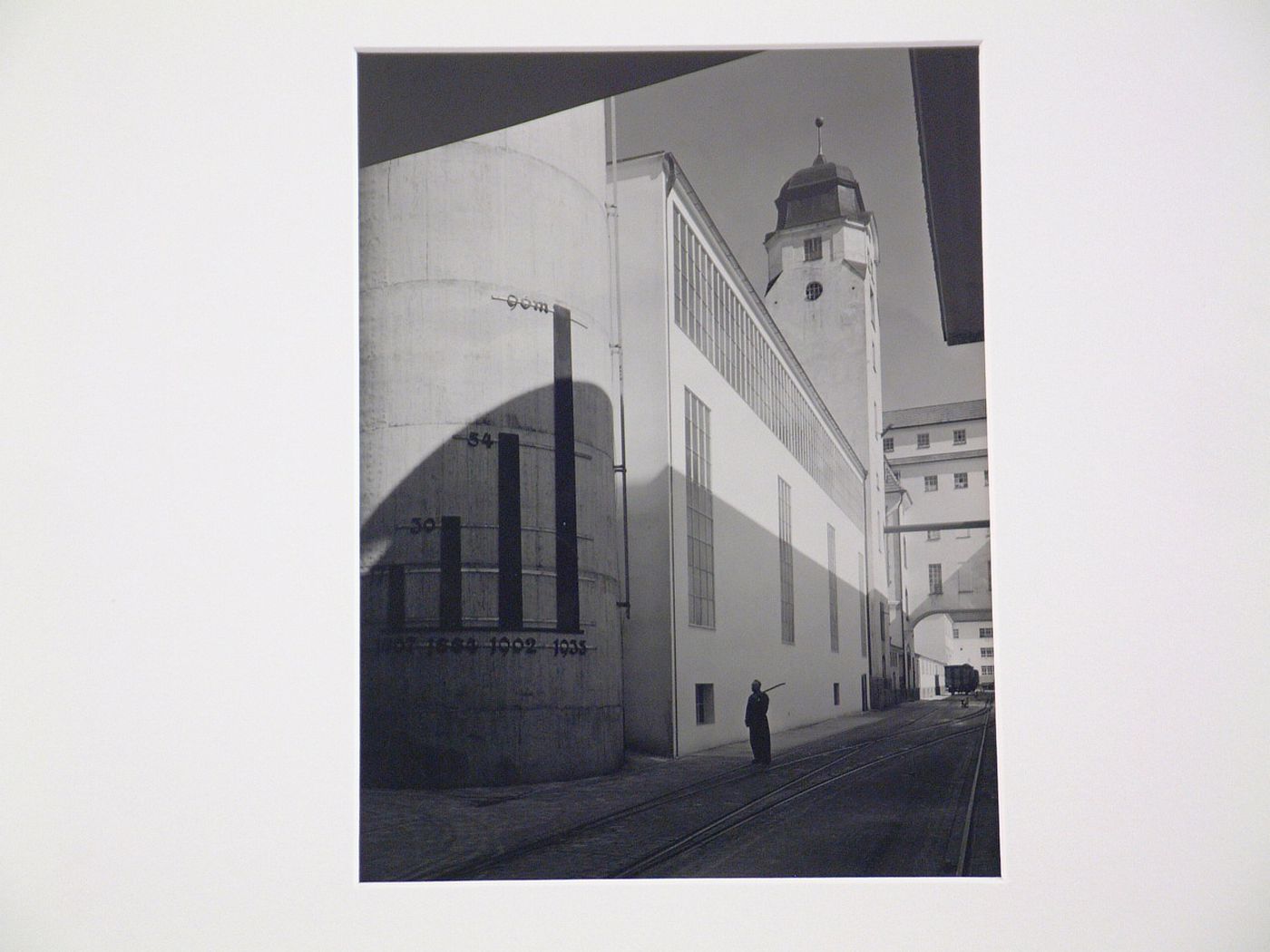 Exterior view of large building with chart on façade, train tracks in foreground, Germany