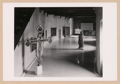 Interior view of a gallery showing a freestanding painted crucifix, a statue and paintings, Museo di Castelvecchio, Verona, Italy
