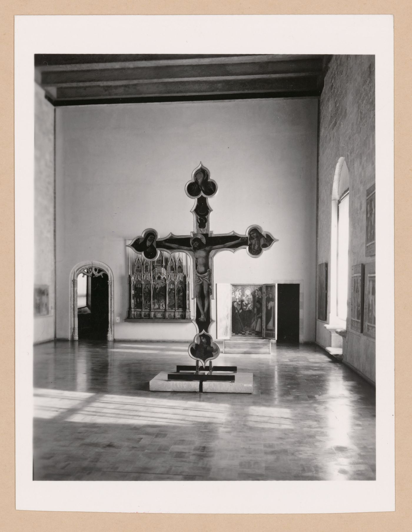 Interior view of a gallery showing a freestanding painted crucifix and paintings, Palazzo Abatellis, Galleria regionale della Sicilia, Palermo, Italy