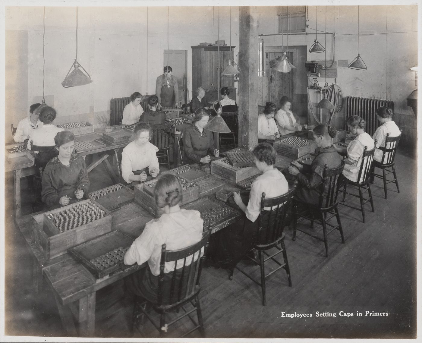 Interior view of workers setting caps in primers at the Energite Explosives Plant No. 3, the Shell Loading Plant, Renfrew, Ontario, Canada