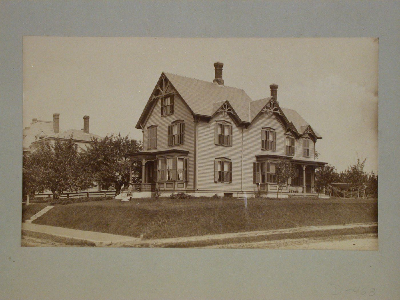 Large wooden house with two porches, decorative bargeboards and shutters