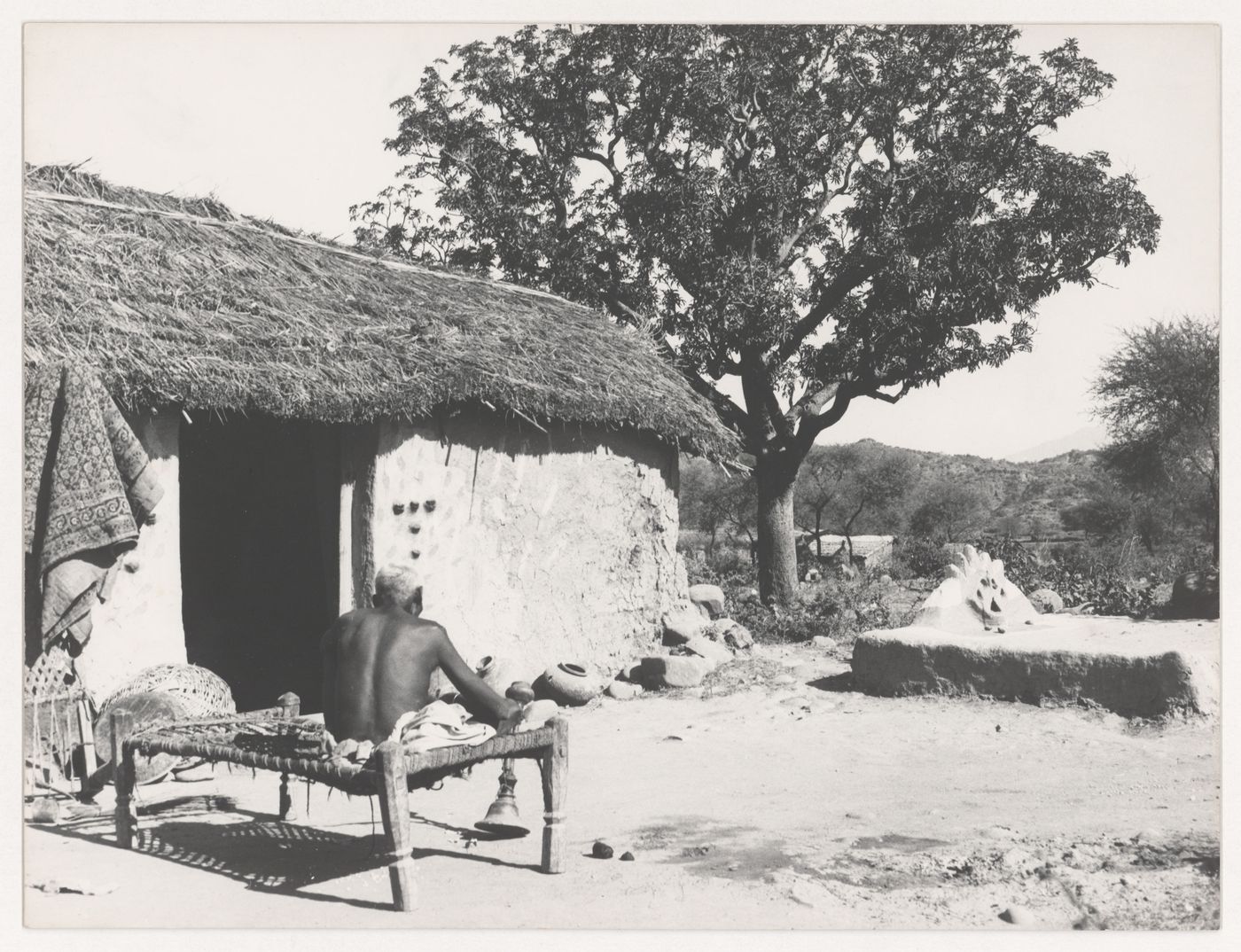 View of seated man in rural housing complex near Chandigarh, India