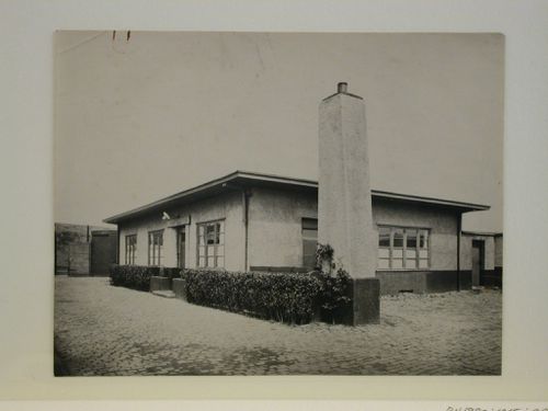 View of a one-storey house with a large detached chimney tower