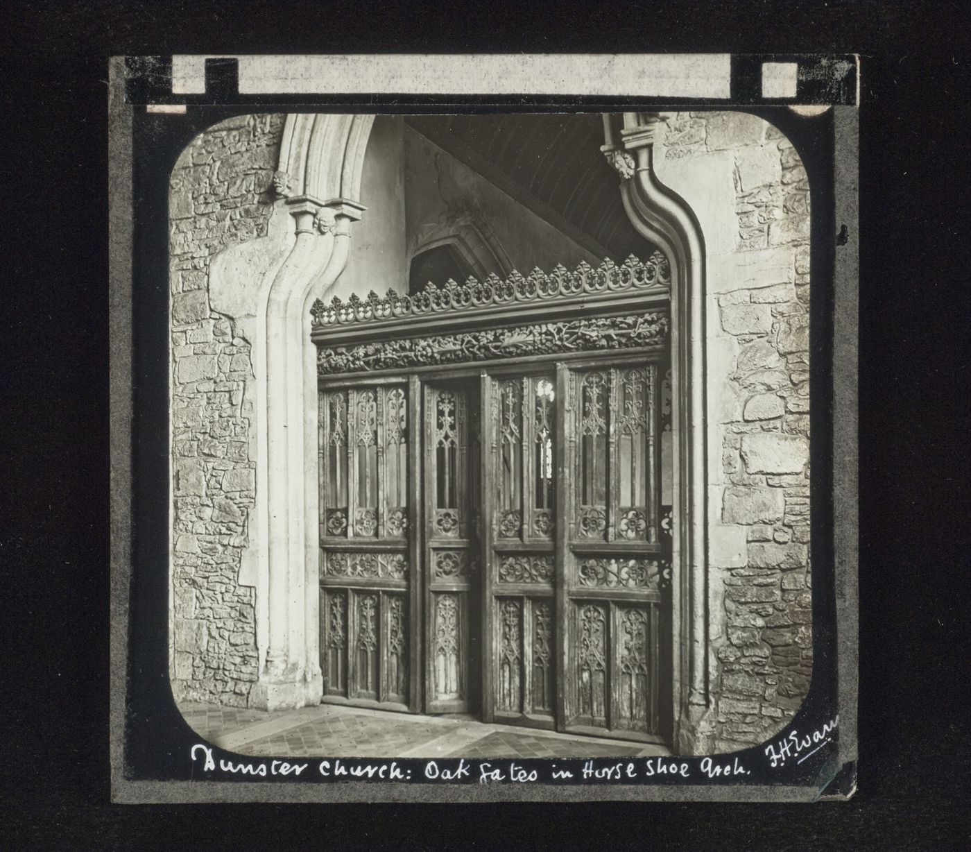 View of oak gates within a horse shoe arch, Dunster Church, Somerset, England