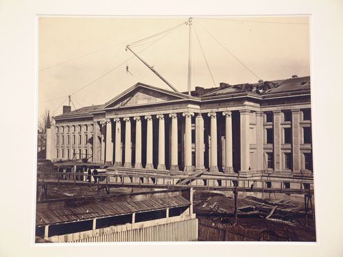 Treasury Building under construction: Crane on roof, figures on wooden ramp looking down to ground leves, Washington, District of Columbia