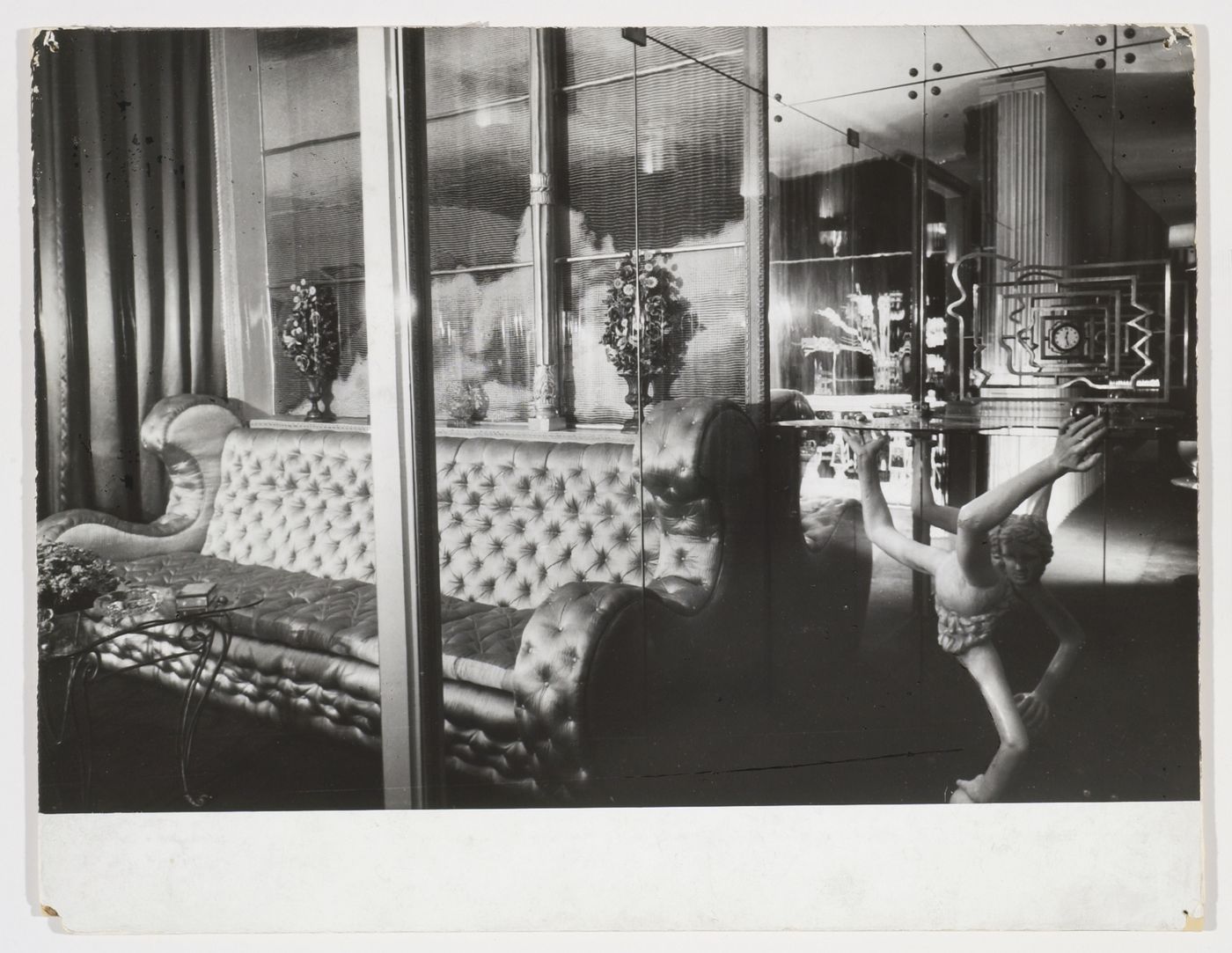 Interior view of Casa Devalle showing a mirrored room with a silver satin divan, a glass wall with gilded columns through which a photographic enlargement of clouds and sky can be seen, and a tempered glass table modelled by Italo Cremona, Turin, Italy