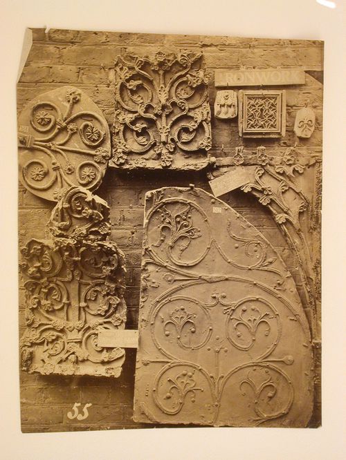 Close-up view of eight casts made from various pieces of decorative ironwork, hanging on a brick wall, England