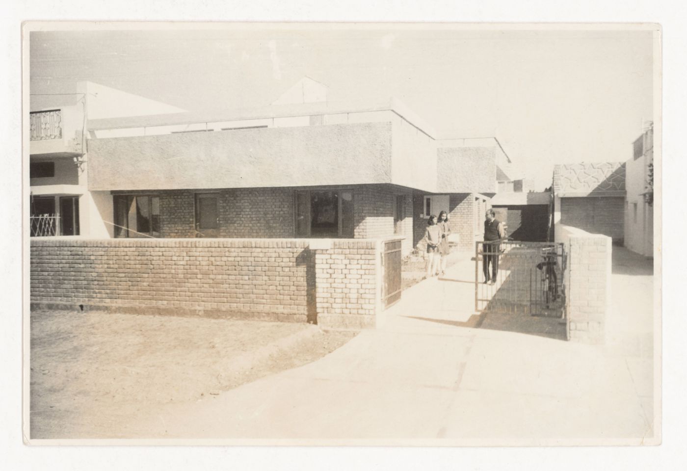 Photograph of Prakash family and unidentified house