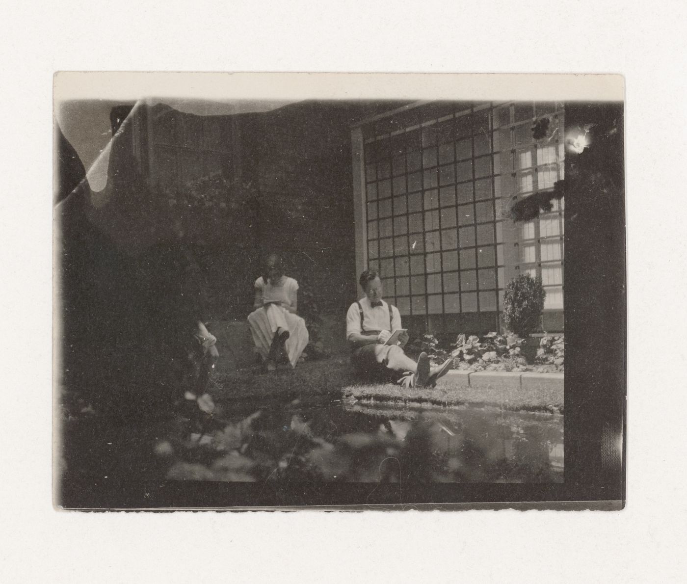 Ernest Cormier et une femme assis dans le jardin de l'atelier d'Ernest Cormier, Montréal, Québec