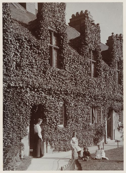 View of woman and children outside Cross Street cottages, Port Sunlight, England, United Kindgom