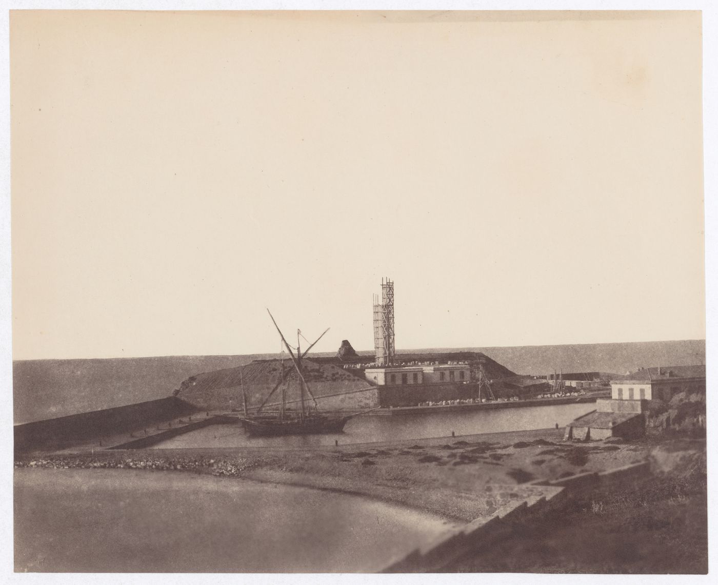 Boat moored on a river with building under construction on bank, Algeria
