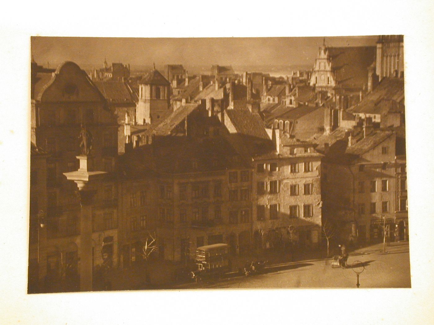 Bird's eye-view of the column of King Sigismund III and buildings on the west side of Zamkowy Square, including a partial view of the gable-roofed Jesuit Church and the Basilica of the Decapitation of St. John the Baptist in the background, Warsaw, Poland