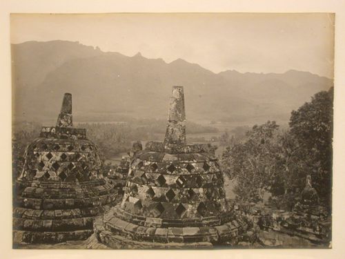 View of stone stupas on one of the upper terraces of the temple of Borobudur with the Menoreh mountains in the distance, Borobudur, Indonesia