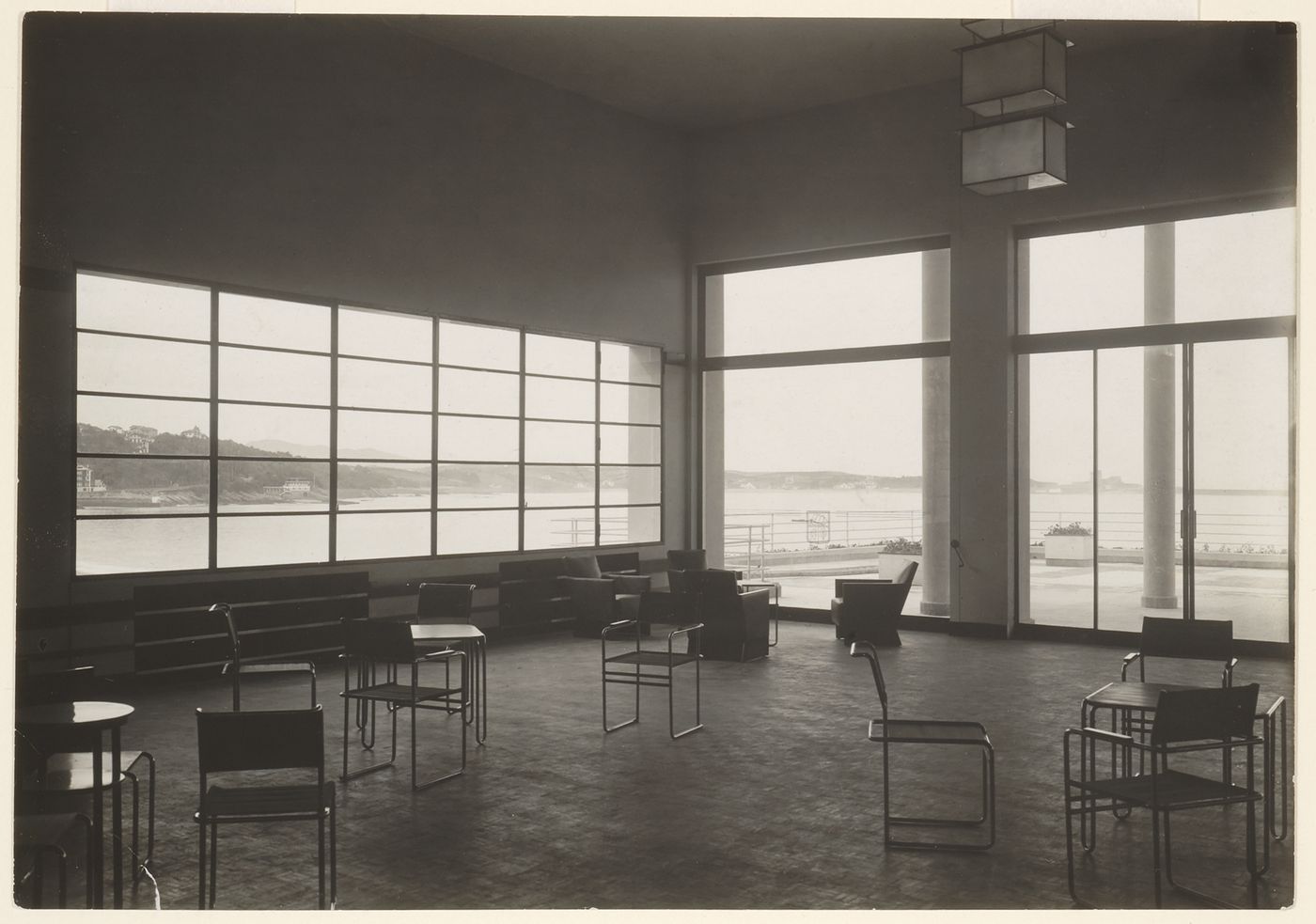 Interior view, room with scattered chairs and large windows, through which the bay is visible, Saint-Jean-de-Luz, France