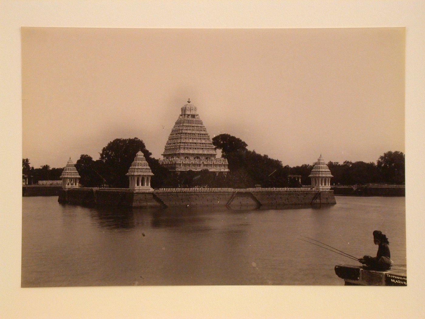 View of three pavilions on the Vandiyur Teppakulam (also known as Vandiyur Mariamman Teppakulam) water tank, and the Meenakshi Temple in the background, Madura (now Madurai), India