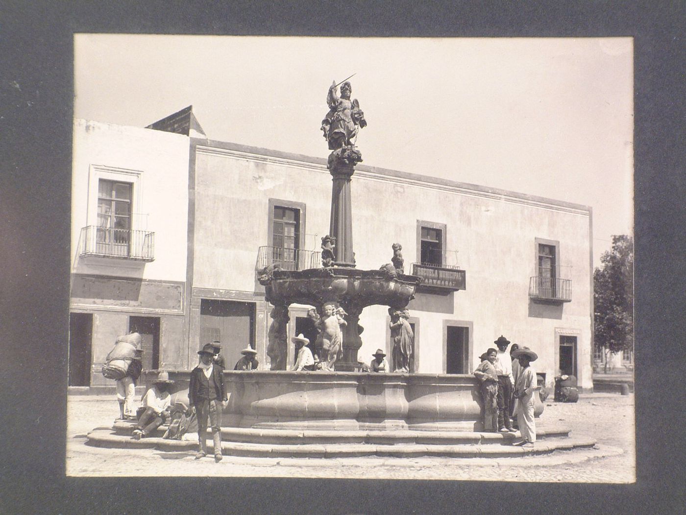 View of the San Miguel Fountain and people in the Plaza de la Constitución with buildings in the background, Puebla, Mexico