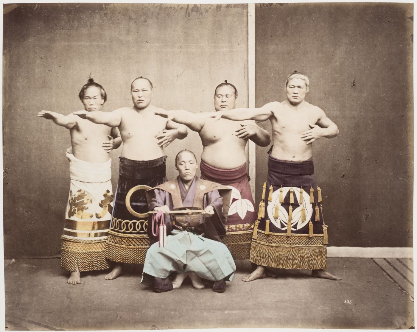 Group portrait of four sumo wrestlers and a gyoji [referee], Japan