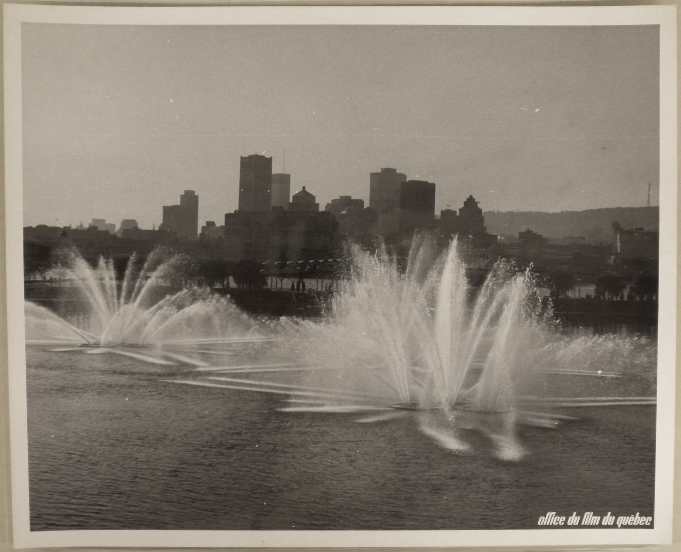 Partial view of the Dancing Waters show at the Dolphin Lake at La Ronde with Montréal as background, Expo 67, Montréal, Québec