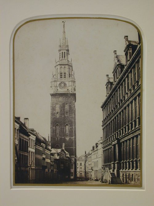View of large church tower, and smaller buildings in narrow square, Belgium ?