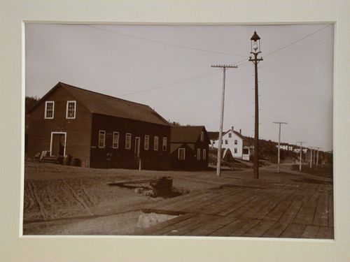 View of houses by the road, wooden platform, street light and telephone poles on right