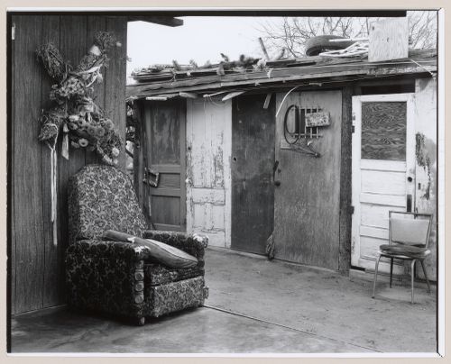 View of cross decorated with flowers hung above upholstered chair in outdoor space, Old Pascua, Tucson, Arizona, United States (from a series documenting the Yaqui community of Old Pascua)