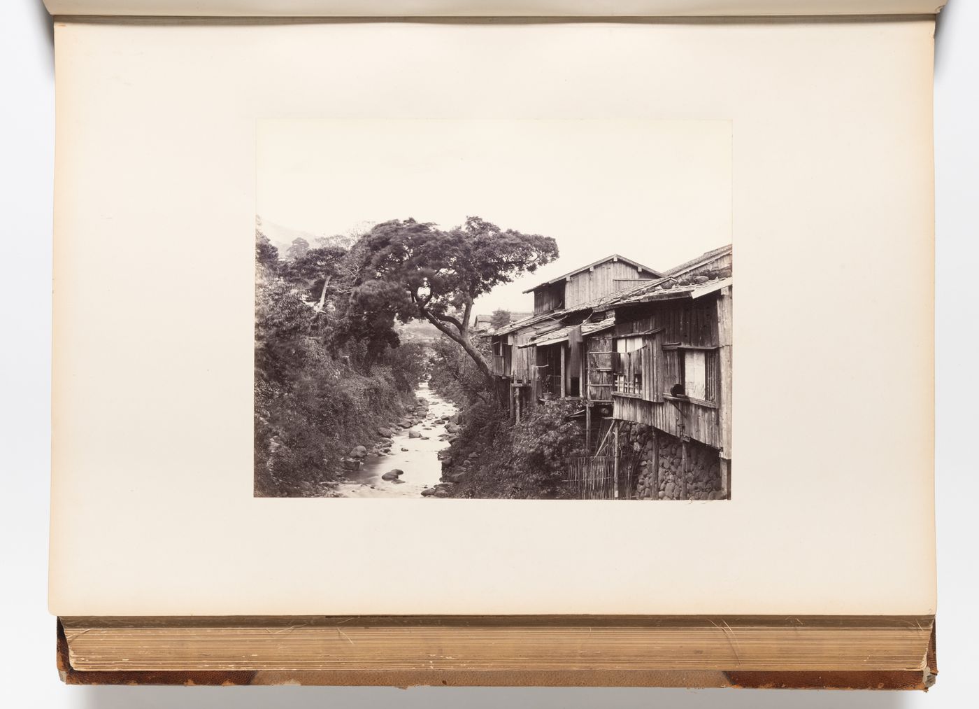 View of houses and the Nakashima River showing a stone arch bridge in the background, Nagasaki, Japan